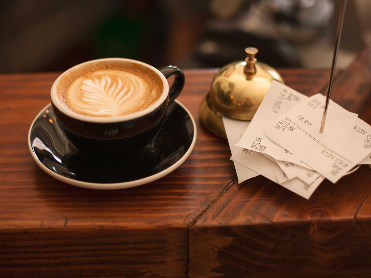 O cafea și niște bonuri pe o masă